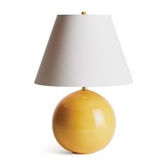 a yellow lamp with a white shade on it