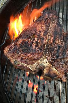 steaks cooking on the grill with flames coming out of it's back end