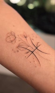 a woman's arm with a cross and flowers tattoo on the left side of her arm