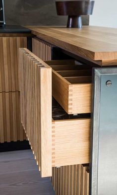 an open drawer in the center of a wooden table with drawers on top and bottom