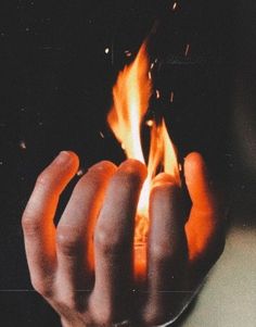 a person holding a lit object in their hand with flames coming out of the top