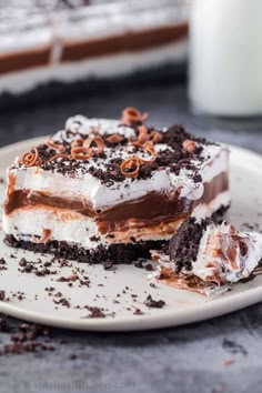 a piece of cake on a plate with chocolate and whipped cream toppings in the middle