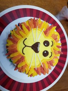 a cake shaped like a lion on top of a white plate with red and yellow stripes