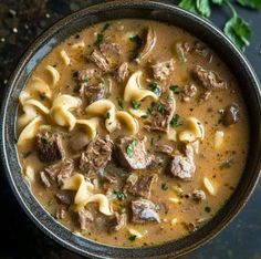 a bowl filled with pasta and meat soup