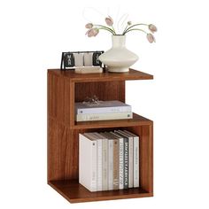 a book shelf with books and a vase on top