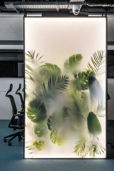 an office cubicle with plants on the wall and two chairs in front of it