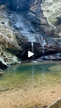 there is a small waterfall in the middle of this mountain stream with clear blue water