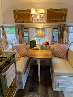 a kitchen area with a table, oven and window in the back side of it