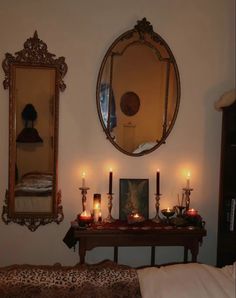 candles are lit in front of a mirror on the wall next to a leopard print bed