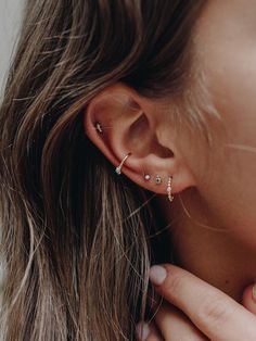 a close up of a woman's ear with three small diamond studs