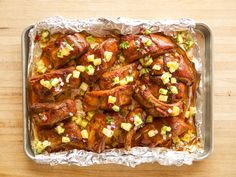 chicken wings with pineapple salsa in a tin foil pan on a wooden table top