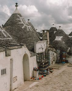 an old building with many roof tops and some buckets on the ground next to it