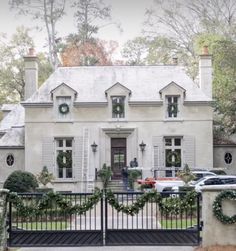 a white house with wreaths on the front gate