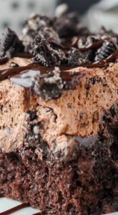 a close up of a piece of cake with chocolate frosting and oreo cookies