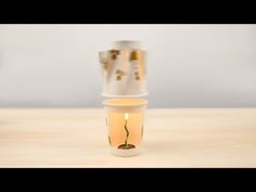 a stack of three cups sitting on top of a wooden table next to each other