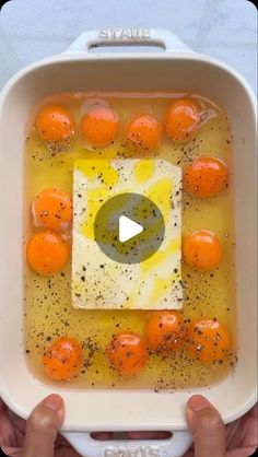 someone is holding a bowl with oranges in it and the video appears to be showing