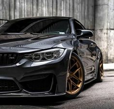 a black car with gold rims parked in front of a building