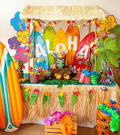 a surfboard themed birthday party with tropical decorations and luau decorating on the table