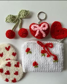 crocheted items displayed on white surface including purse, mitts and cherries