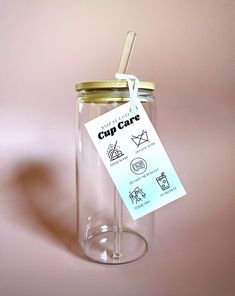 a glass jar with a label on it and a straw sticking out of the top