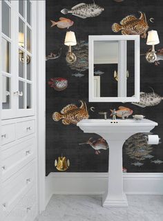 a bathroom with a sink, mirror and wallpaper