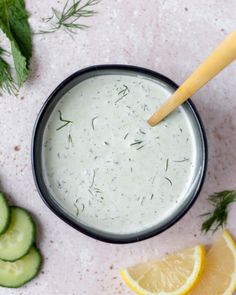 cucumber and lemon slices next to a bowl of ranch dressing