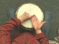 a person sitting down with their hands on a drum