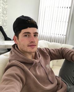 a young man sitting on top of a white couch