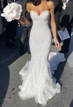 a woman in a wedding dress walking down the street