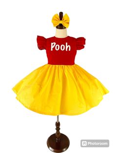 This adorable Winnie the Pooh inspired dress is perfect for any special occasion, or even as a cute play dress. The special girl in your life will want to twirl all day in this beautiful dress.    This dress is made with soft cotton fabric, is professionally lined and serged and comes with a cute matching bow.   Dress is made with flutter sleeves. In the personalization box please let me know what word In vinyl you would like for the front on the dress. For example dress pictured is personalized Cute Christmas Princess Dress, Cute Red Princess Dress For Birthday, Cute Yellow Dress For First Birthday, Cute Yellow Dress For Costume Party, Cute Short Sleeve Princess Dress For Birthday, Playful Red Dress For First Birthday, Princess Dress With Short Sleeves For First Birthday, Princess Style Dress With Short Sleeves For First Birthday, Cute Fitted Princess Dress For Easter