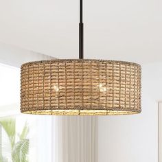 a rattan chandelier hanging from a ceiling in a living room with white walls