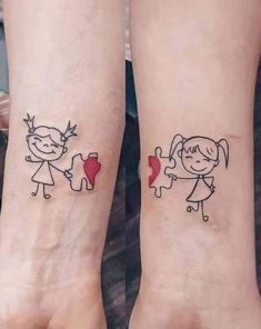 two small tattoos on the wrists of people holding hands with hearts and arrows in them