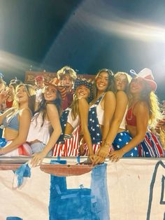 a group of young women standing next to each other in front of a flag banner