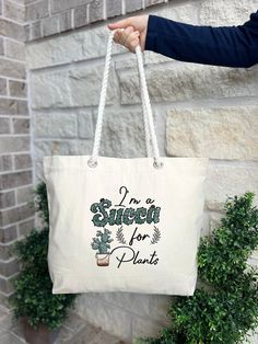 a person holding a white bag that says, i'm sweet for plants