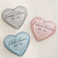 three heart shaped glass magnets with the names of two different people and one has an angel