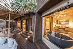 an outdoor living area with wooden flooring and large tub in the middle of it