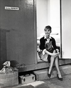 a black and white photo of a woman sitting in front of a mirror holding a small child