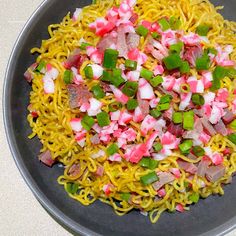 a bowl filled with noodles and veggies on top of a white countertop