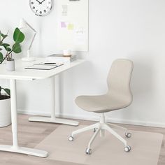 an office chair sitting in front of a desk with a clock on the wall