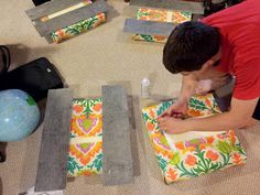 a man is working on some art work in the middle of a room with other items