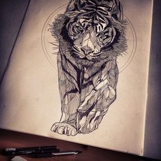 a drawing of a tiger on top of a book with pen and ink next to it