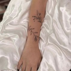 a woman's foot with a flower tattoo on the left side of her arm