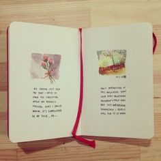 an open book with watercolors and writing on the pages is sitting on a wooden table