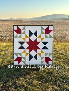 a quilt on the grass with mountains in the background