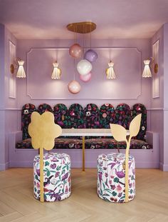 a room with purple walls and furniture in the center, along with balloons hanging from the ceiling