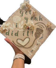 someone is holding up a graduation cap with flowers on it