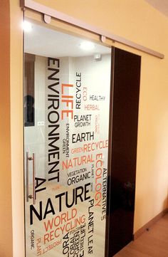 a glass door with words written on it in different languages and colors, inside an office building