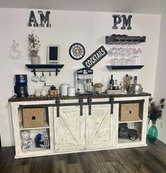 a room with some shelves filled with bottles and glasses on top of each shelf in front of a clock