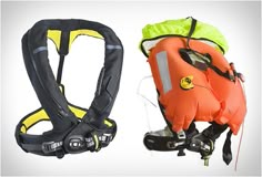 two life vests one orange and the other black, both have safety equipment attached to them