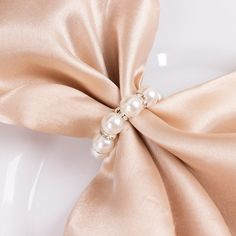 a close up of a bow with pearls on it